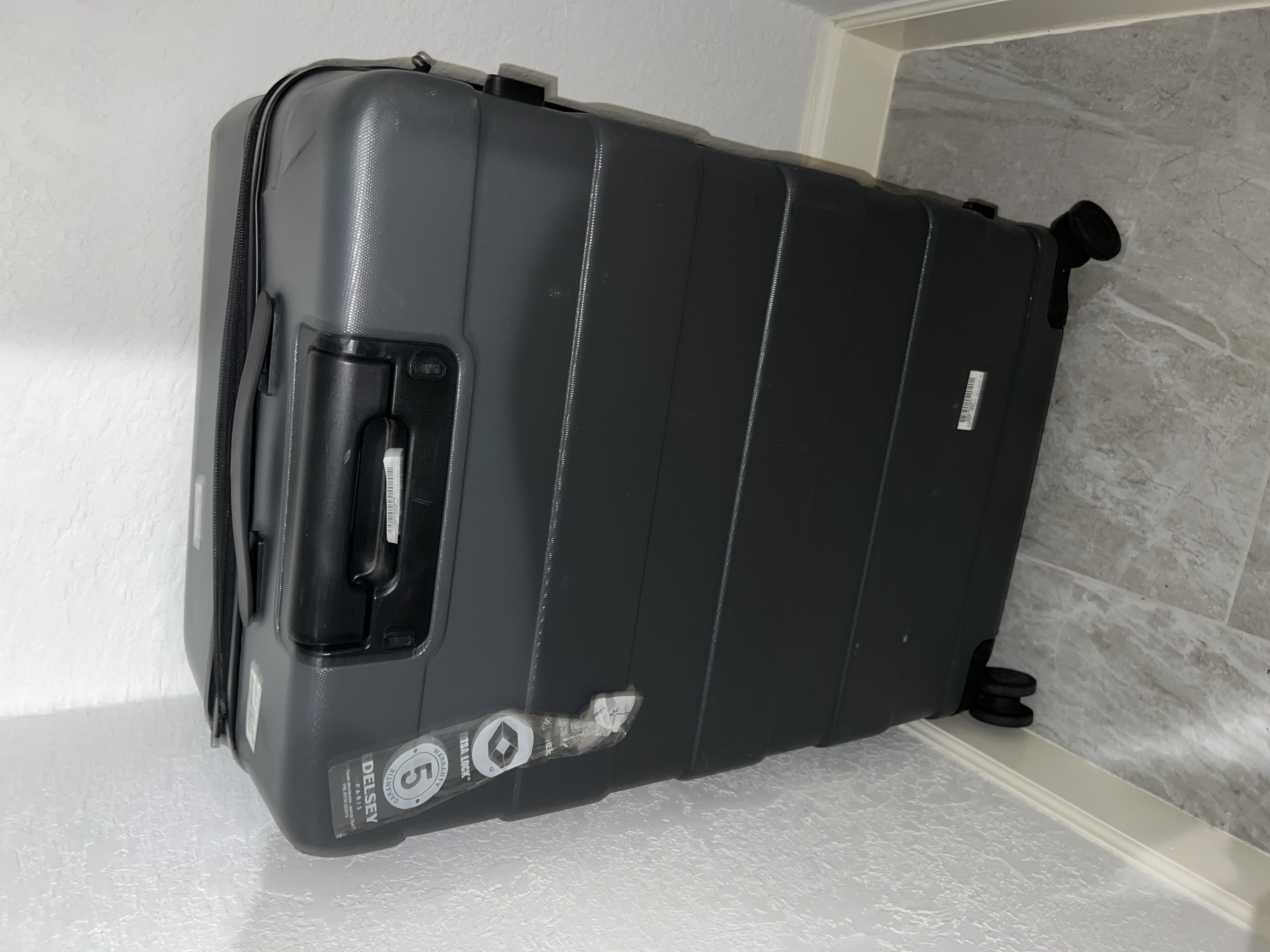 Large, grey, checked roller bag.