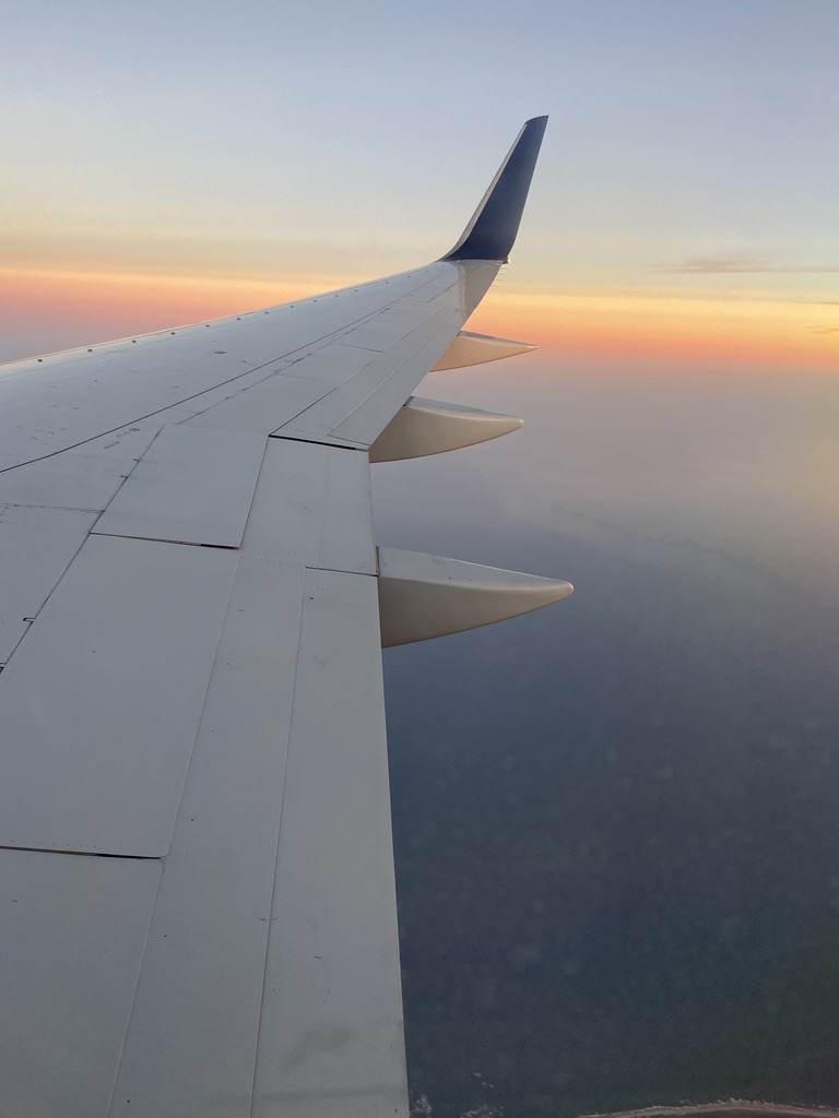 View of airplane wing out of plane window.