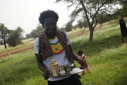 Young man holding tea set.