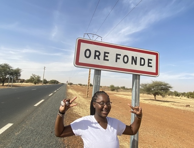 Girl smiling in front of sign that reads 'Orefonde'.